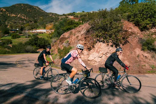 Group of three BR guests riding, one is pointing at the camera.