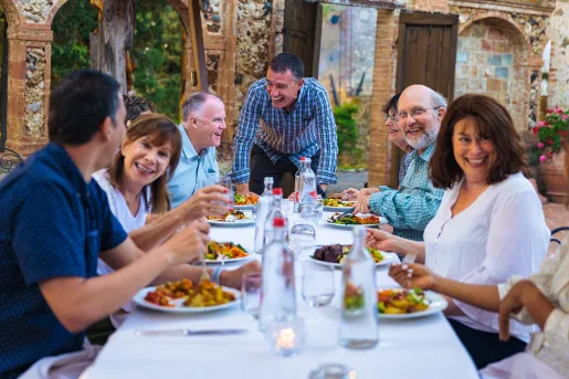 Group of guests at dinner, smiling and laughing.