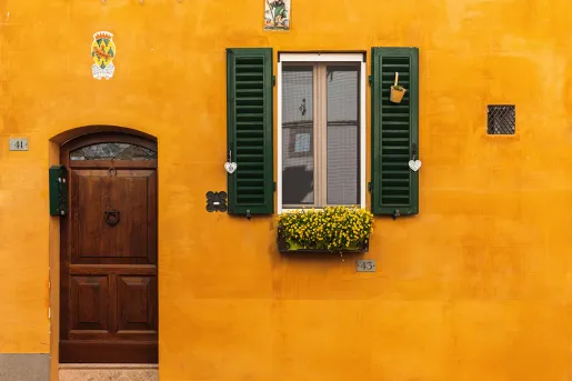Shot of orange building, window, wooden door.