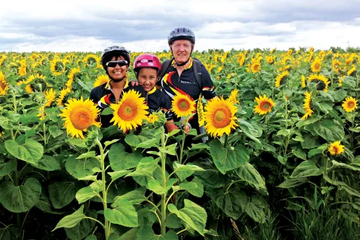 Backroads guests smiling among a field of sunflowers