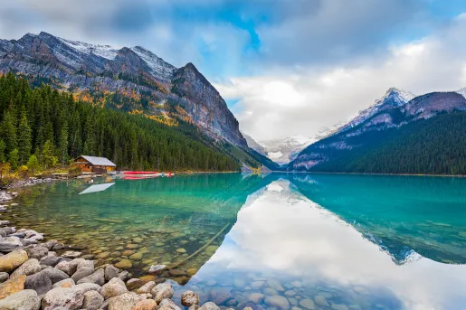Large lake vista, wooden shack, mountains in background.