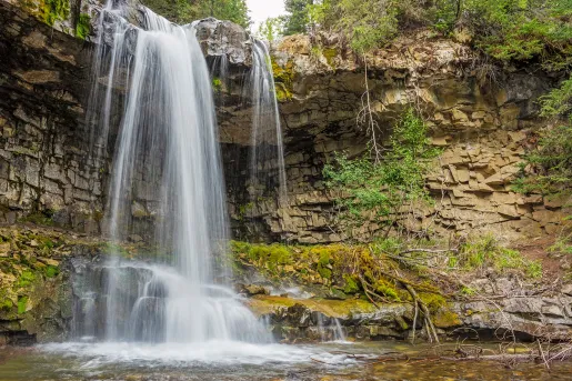 Shot of waterfall flowing into small lake.