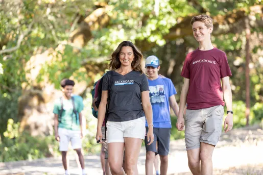 Group of guests walking on trail, one smiling at camera.