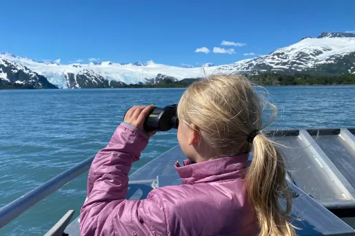 Child with binoculars on boat