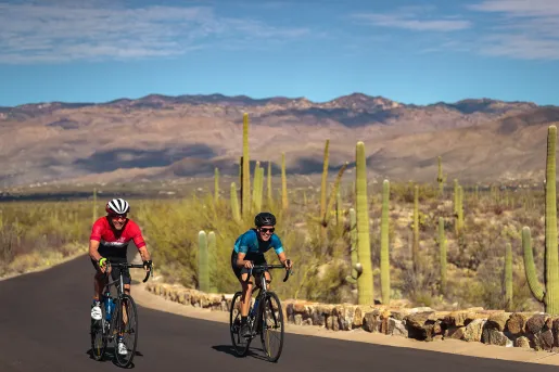 Biker wearing red, biker wearing blue, on road in AZ