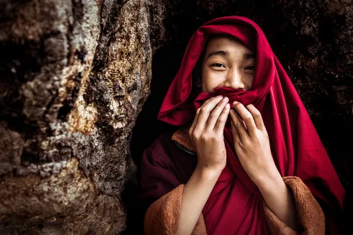 Monk smiling and covering their mouth in Bhutan