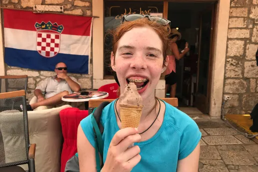 Young guest with ice cream cone, smiling at camera.