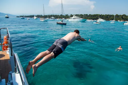 Backroads guest diving into the sea from the side of a boat