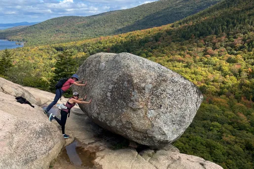 Two guests pretending to push large boulder off a cliff.