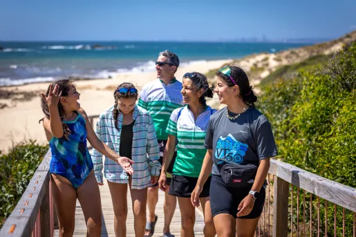 Family walking up wooden steps leading away from a sandy beach