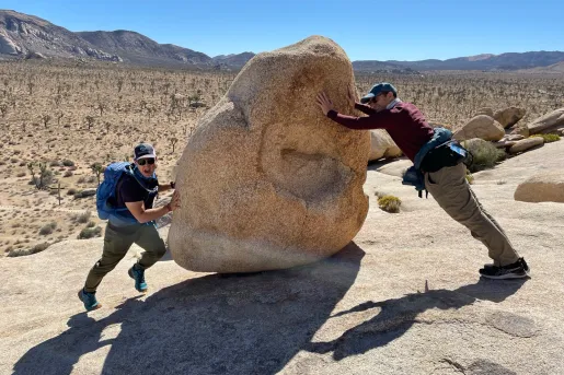 Guest and leader fake pushing a boulder.