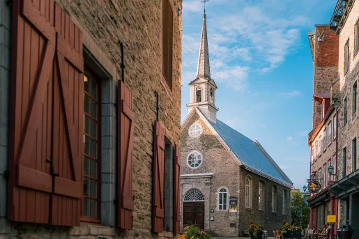 Shot of town square, all buildings made of grey brick.