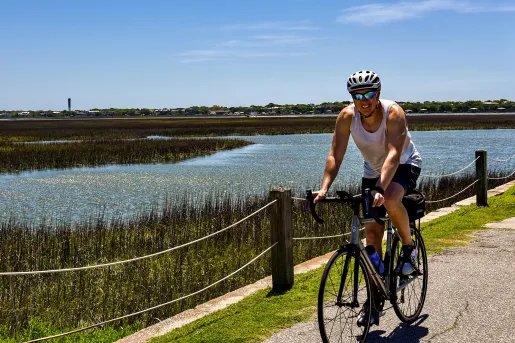Guest cycling past grassy bog.