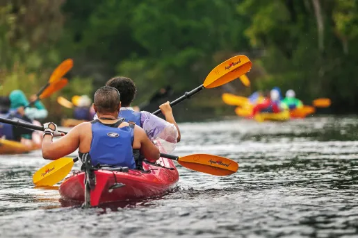 Group of guests kayaking in the rain.