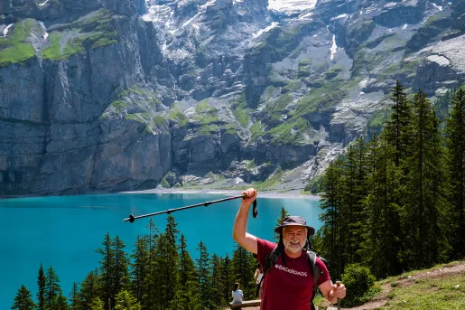 Guest raising pole in celebration, large mountains, lake in background. 
