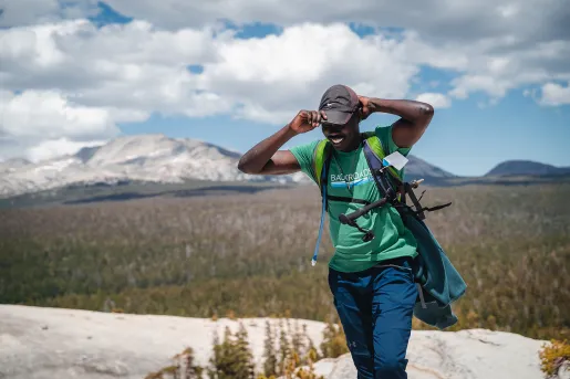 Guest/leader on mountaintop, forest floor in background. 