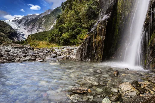 Waterfall flowing into a crystal clear river