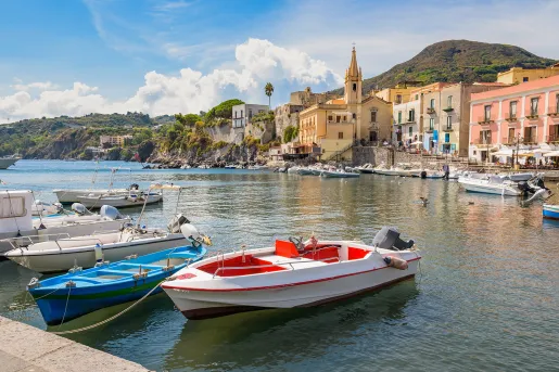 Point of view shot of pier, boats, ocean, hillside, seaside town.