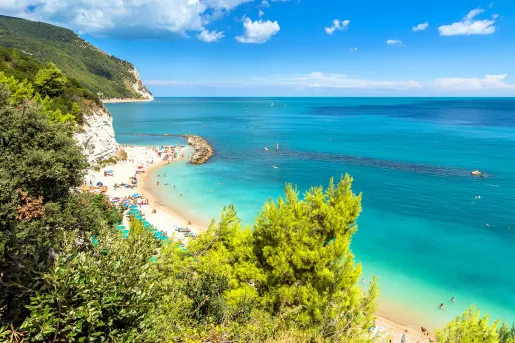 Wide shot of vibrant blue coast, ocean in distance.
