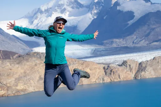 Woman posing for camera, jumping into air.