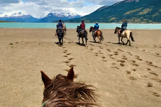 Point of view shot of guests on horseback, heading towards beach.