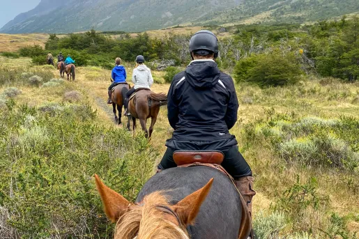 Point of view shot of guests on horseback, heading towards ring of mountains.