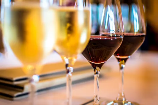 Close-up of four wine glasses, two red, two white.