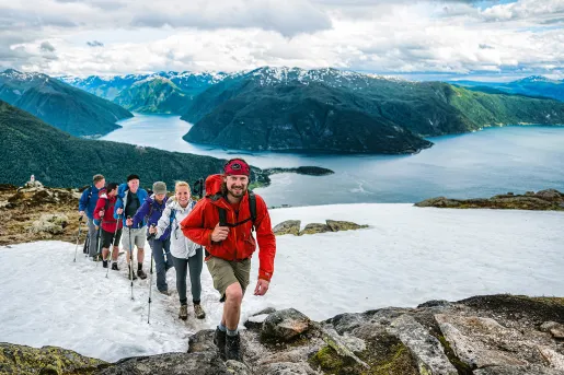 Hikers climbing a snowy ridge in Norway