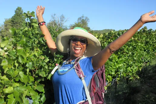 Backroads Guest in Front of Grape Vines with Hands in the Air 