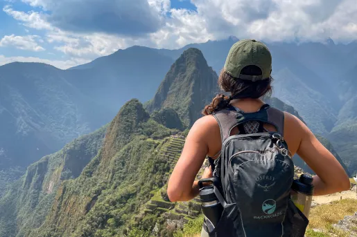 Guest overlooking Machu Picchu from high cliff.