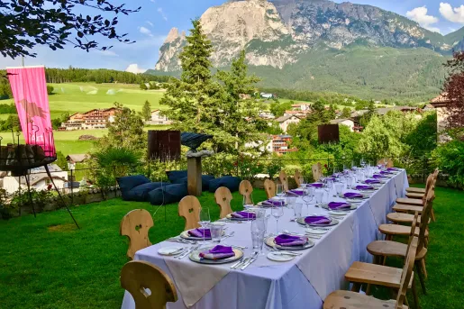 Long outdoor dining table set for a meal amid the Dolomites