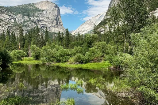 Shot of small, pristine lake, mountain in background.