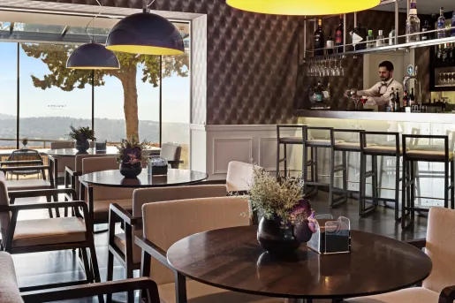 Indoor bar and lounge, with a bartender in the back making drinks