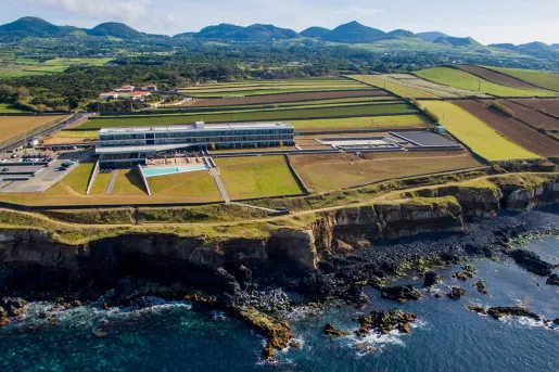 aerial view of hotel surrounded by fields on a cliffside