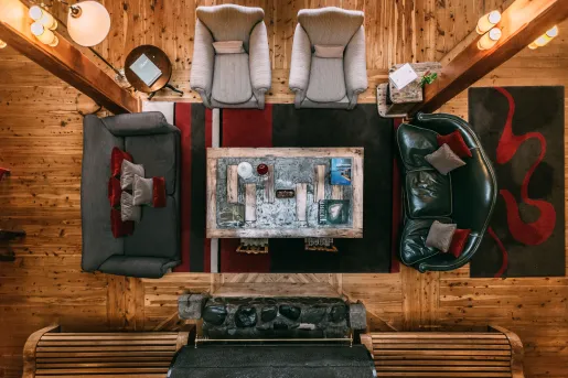Top view of a lodge lobby with a wooden coffee tables and sofas surrounding the table