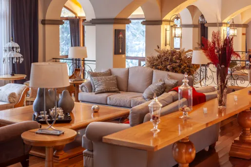 Indoor lobby with gray sofas surrounding a coffee table with large windows in the back