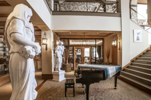Large lobby with stone statues and a piano in the center