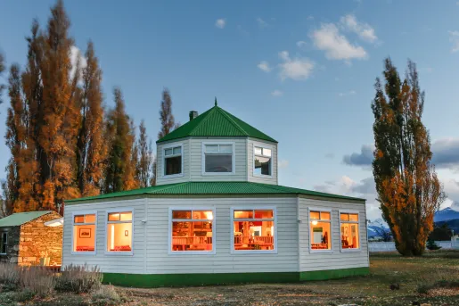 round house with green roof and lit up windows