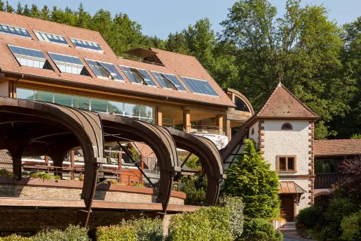 Exterior view of a brown building with large windows and curved archways