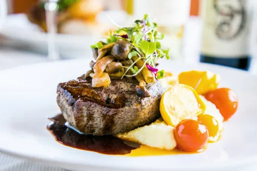 Plate of steak with mushrooms and vegetables on the side