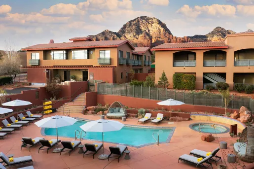 Exterior view of hotel building with outdoor pool and hot tub