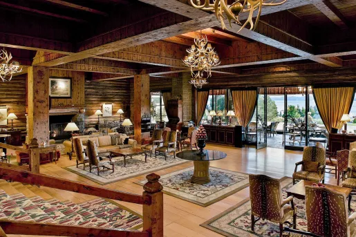Hotel lobby with cushioned chairs, rugs under furniture, and a fireplace