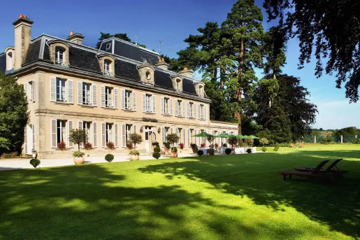 Yellow hotel building with large grass area in front