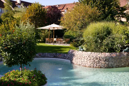 Outdoor garden with tables with plants and a small pond