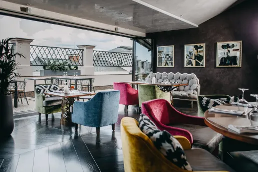 Indoor lounge with open doors leading do a stone balcony