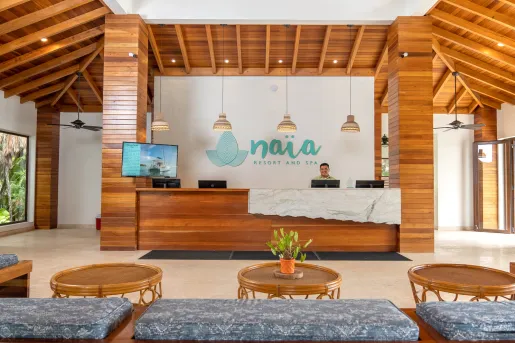 Hotel lobby with circular wooden tables and cushioned benches