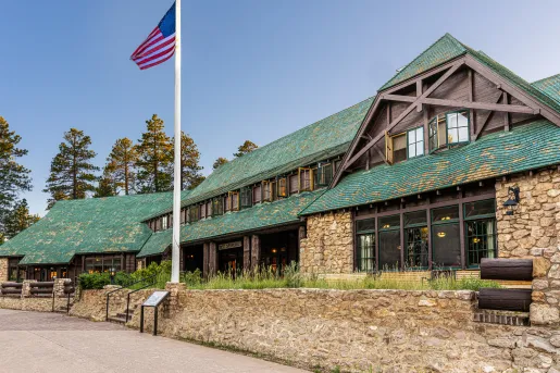 Stone building with green roofing and an American Flag on a pole