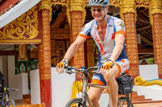 a person bikes in front of a temple