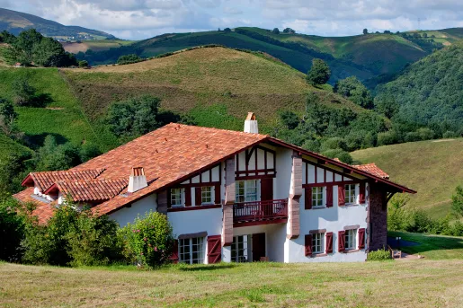 Exterior of white building with red accents and a red roof