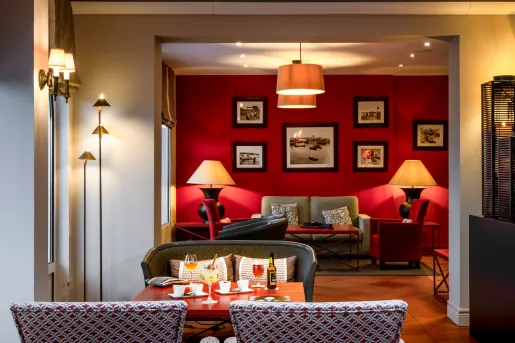 Lounge and dining area with a red wall with paitnings hanging